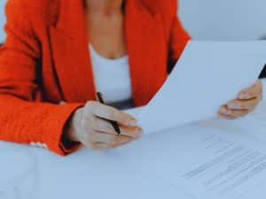 Woman signing documents to switch financial advisers