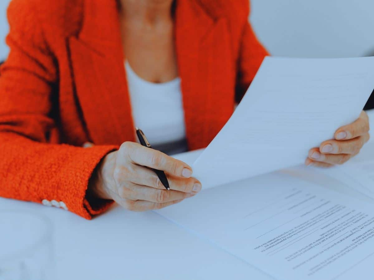 Woman signing documents to switch financial advisers